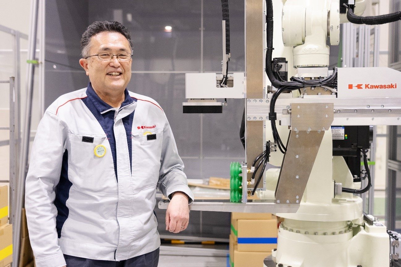 川崎重工 システム技術者の山根氏とロボット